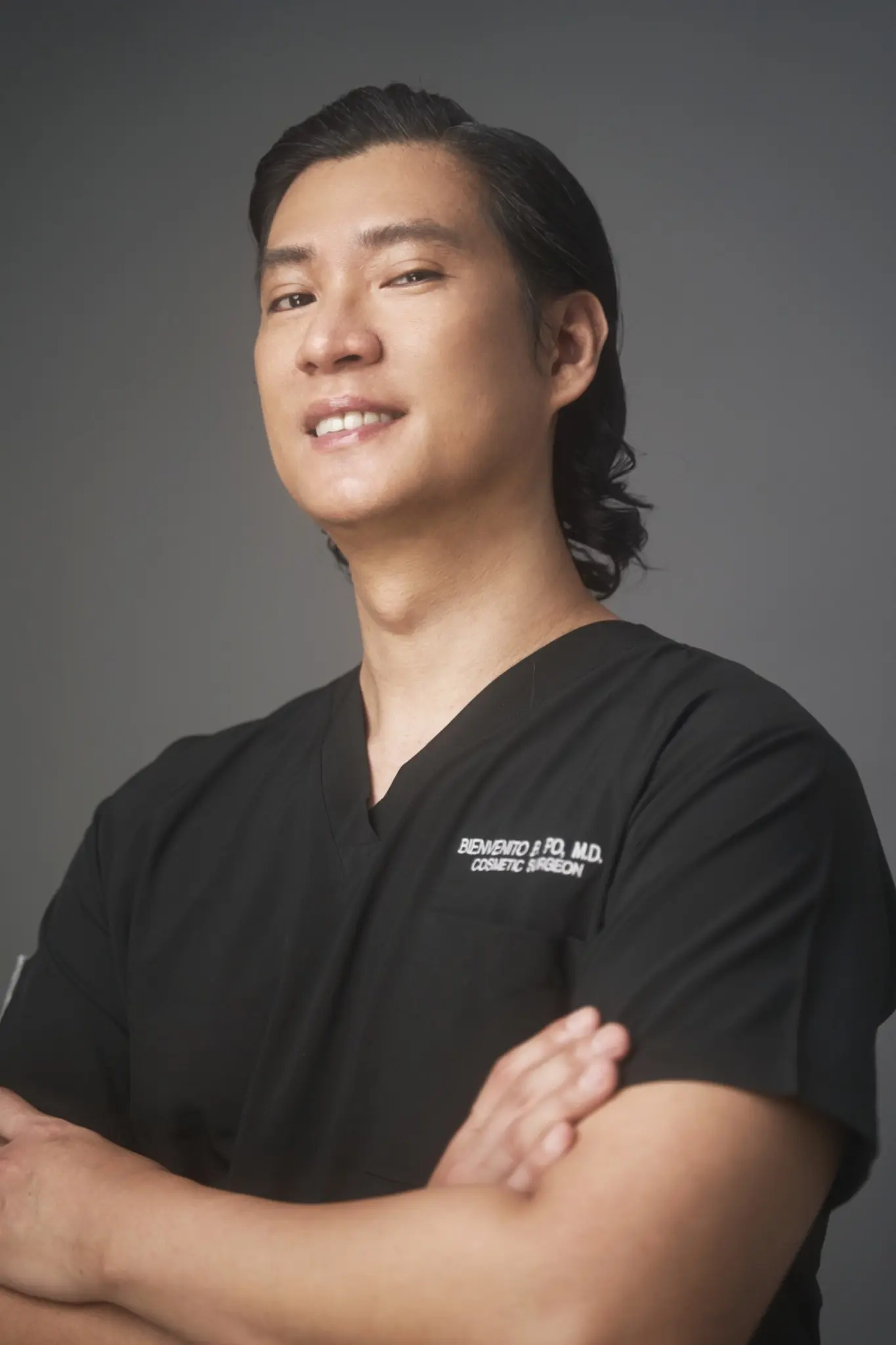 Dr. Bien Po wearing black surgical scrubs