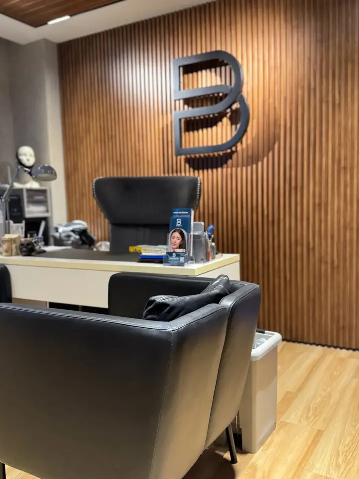 BienPoMD consultation room with wood feature wall and clinic logo