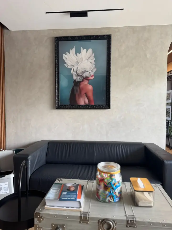 BienPoMD patient lounge with framed artwork and black leather seating