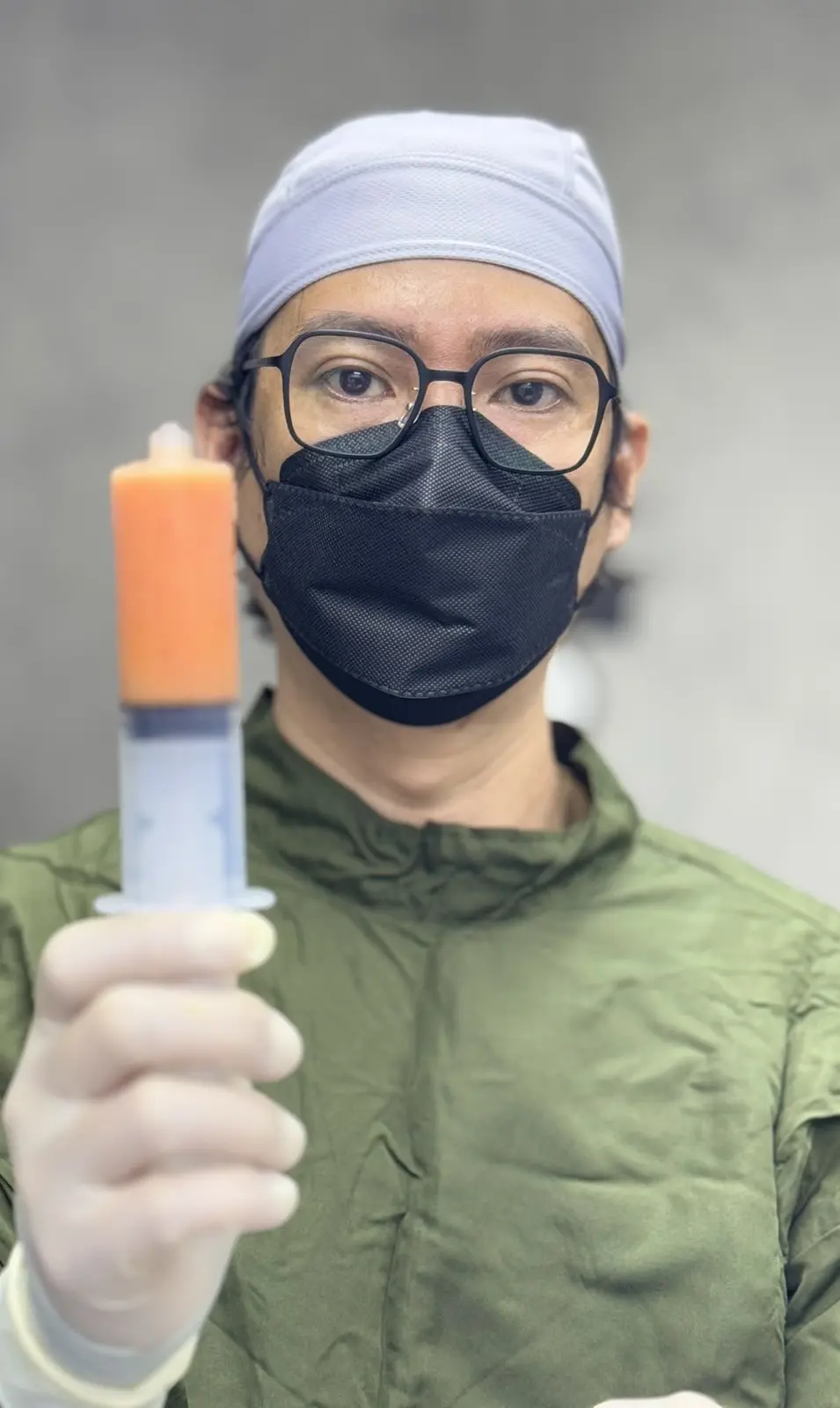 Dr. Bien Po in the operating room preparing a fat-grafting syringe